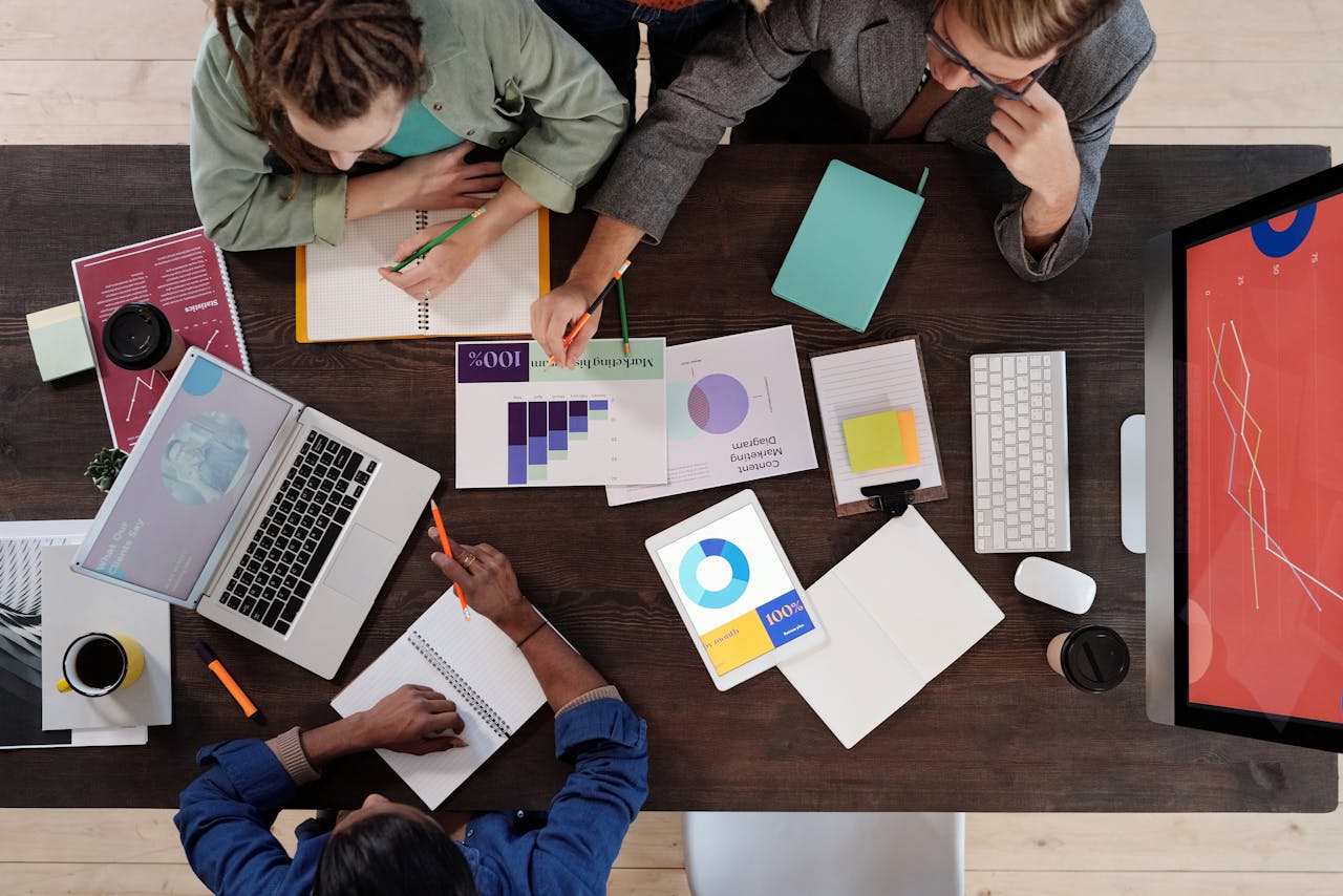 about-01 Overhead view of a diverse team collaborating on a project in a modern office setting.